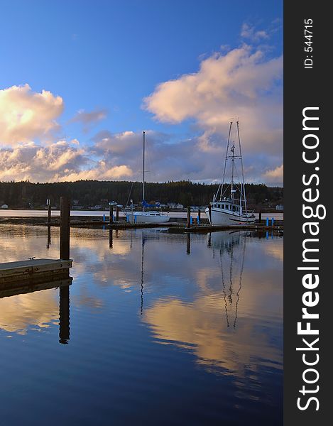 Boats in a marina reflecting on the water. Boats in a marina reflecting on the water