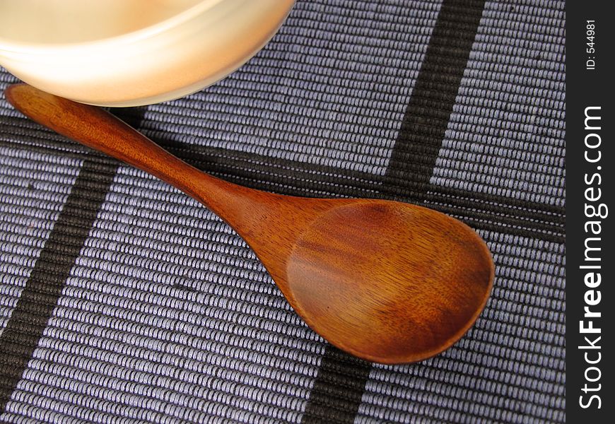 Oriental still life with a wooden spoon and a bowl on a blue material