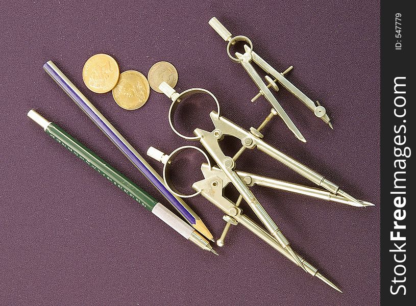 Coins and drafting instruments on a blue background. Coins and drafting instruments on a blue background