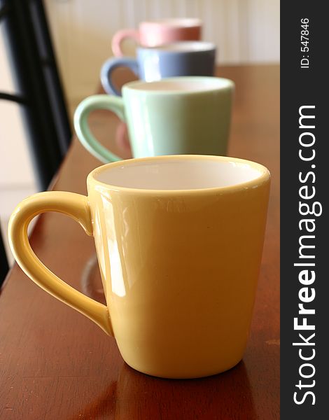 Four multi-coloured mugs arranged in a line
