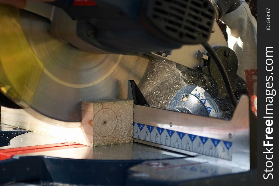 Cutting a piece of lumber with a miter or chop saw. Cutting a piece of lumber with a miter or chop saw.