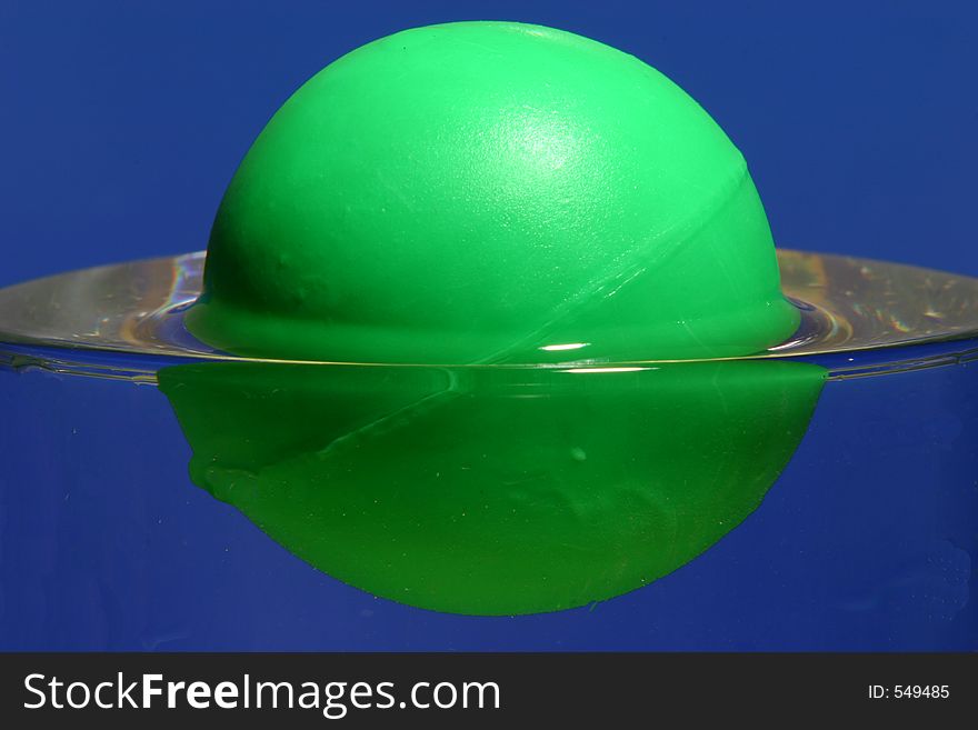 Closeup of a green ball than floats in a water glass,. Closeup of a green ball than floats in a water glass,