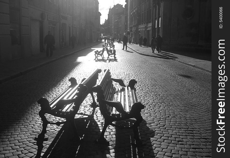 A valley of benches standing in the morning sun in pairs. A valley of benches standing in the morning sun in pairs