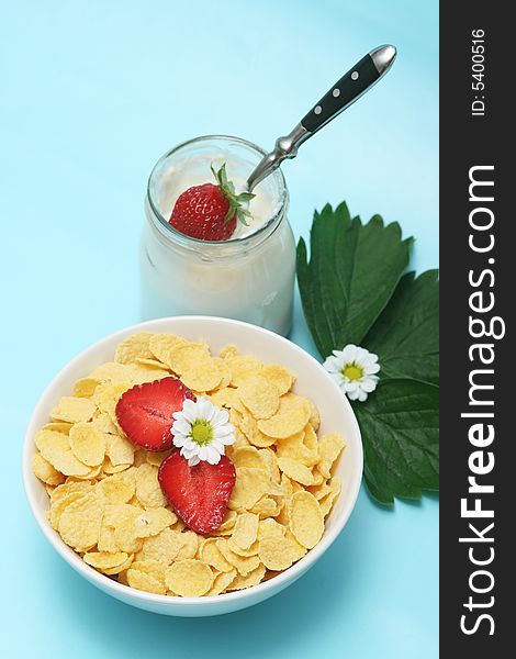 Closeup of open jar of organic yogurt and cornflakes,delicious strawberries with flowers. Closeup of open jar of organic yogurt and cornflakes,delicious strawberries with flowers.