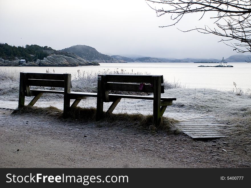 Two benches on the beach in the winter. Two benches on the beach in the winter.