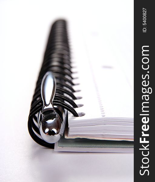 Spiral notepad and pen isolated on white background close-up