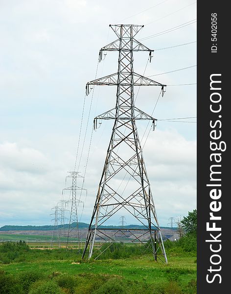 A perspective shot of a row of heavy industrial electrical pylons with room for copy space on the left. A perspective shot of a row of heavy industrial electrical pylons with room for copy space on the left.