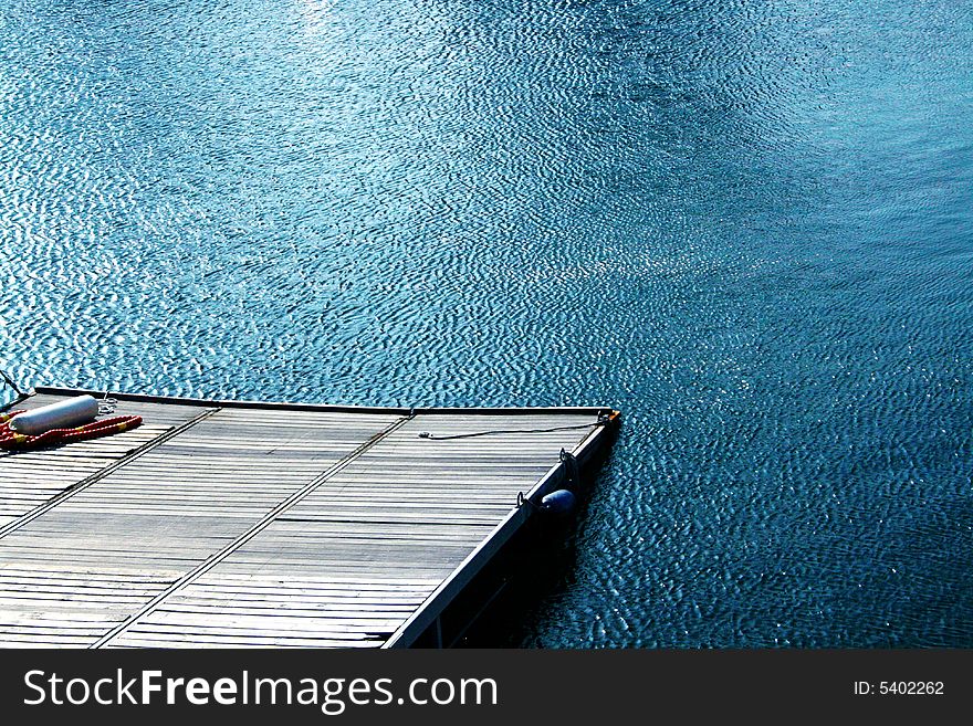 A peacefull place, a wooden pier and blue lake waters. A peacefull place, a wooden pier and blue lake waters