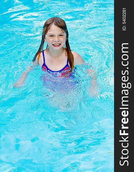 A small girl with big smile in a swimming pool. A small girl with big smile in a swimming pool.