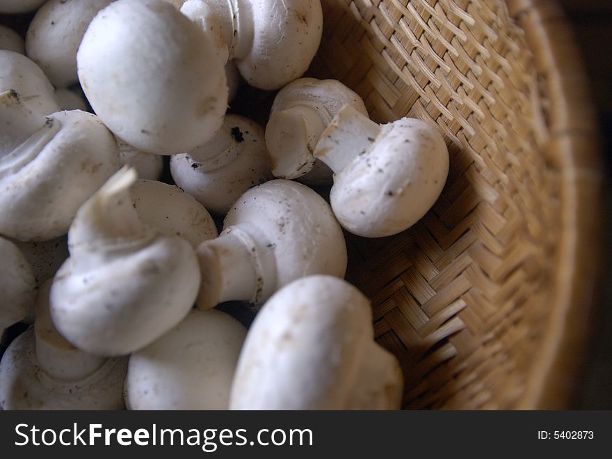 A close up shot of a basket of white mushrooms. A close up shot of a basket of white mushrooms.