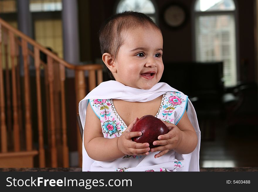 Little baby girl holding an apple