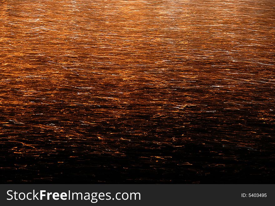 Orange lights reflecting on gently moving water. Orange lights reflecting on gently moving water