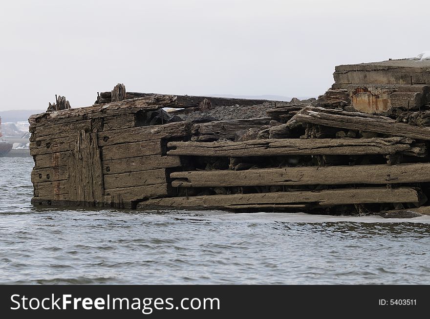 This old wharf was built more than a century ago in the water of the Saint-Lawrence river near Quebec City. The structure still in place but the tides, the current and the ice have slowly but surely eroded it. This old wharf was built more than a century ago in the water of the Saint-Lawrence river near Quebec City. The structure still in place but the tides, the current and the ice have slowly but surely eroded it.