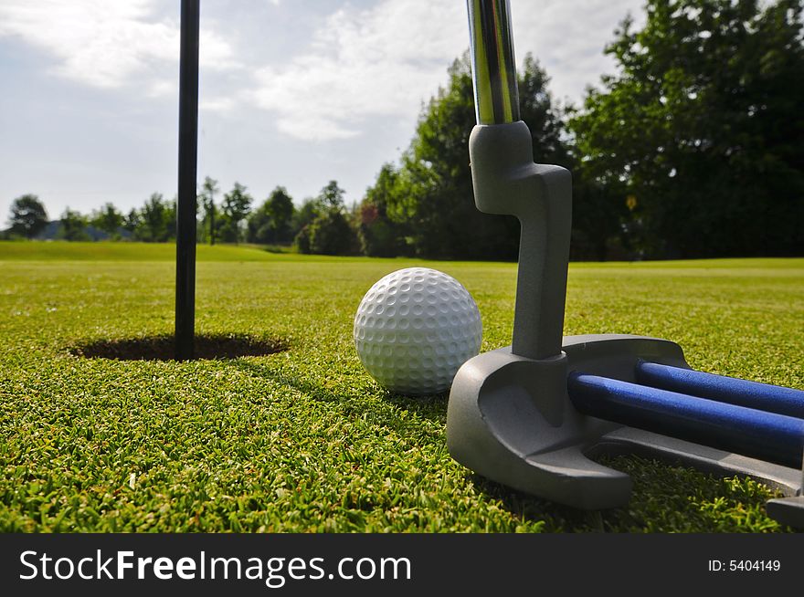 Nice putter on a green with ball and flag. Nice putter on a green with ball and flag