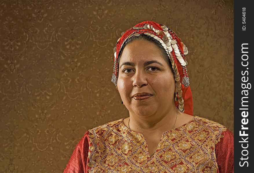 Muslim Woman in a Red Scarf in front of a Gold Wall