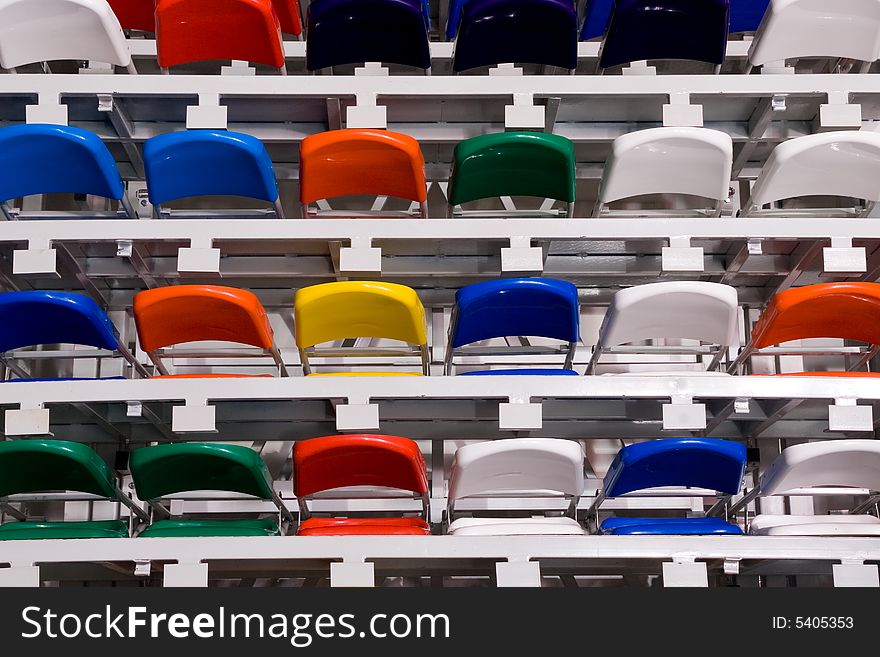 Several rows of multi-coloured plastic stadium seats