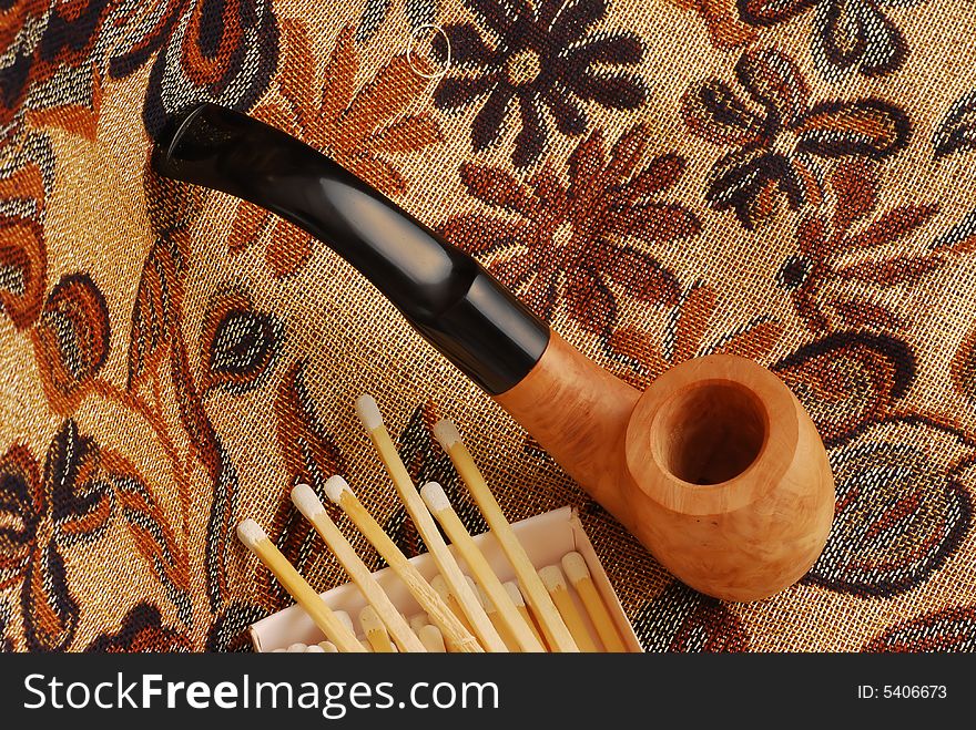 Old pipes with closeup of white tipped wooden match sticks in a match box