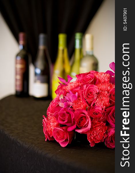 A series of five wine bottles set behind a flower arrangement. A series of five wine bottles set behind a flower arrangement