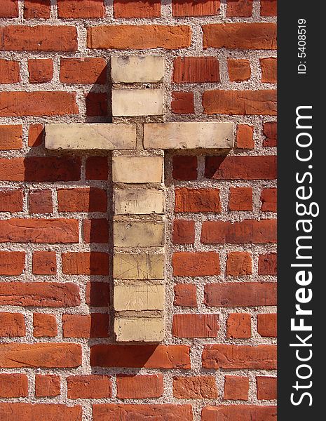 Red brickwall with a cross