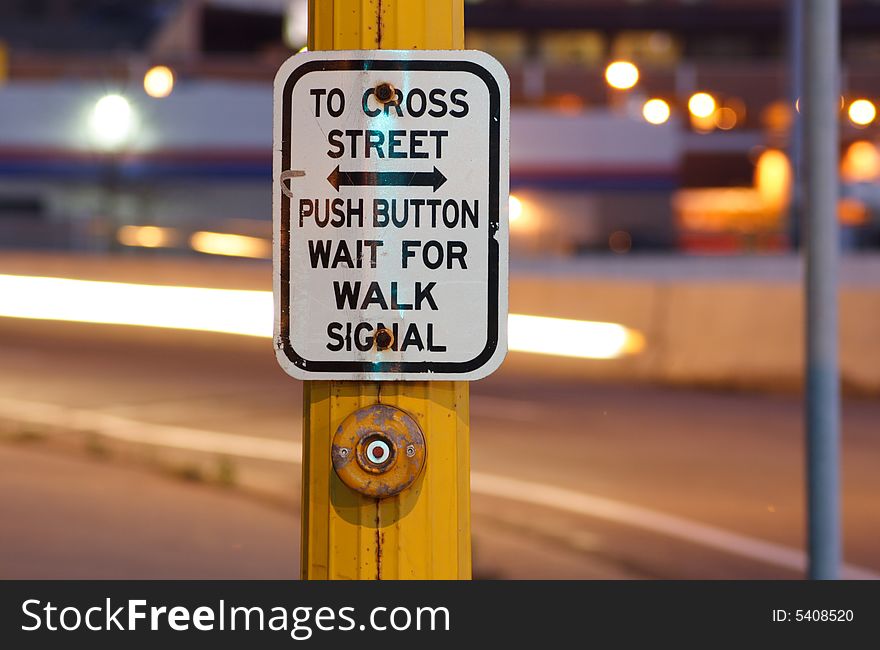 Button and sign at crosswalk at night. Button and sign at crosswalk at night.