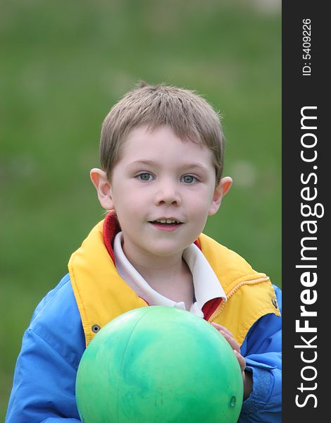 Young boy holding a green ball, looks as if he's getting ready to toss it. Young boy holding a green ball, looks as if he's getting ready to toss it.