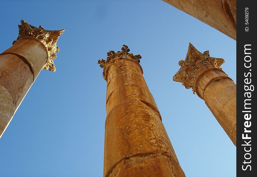 Three Roman columns with blue sky