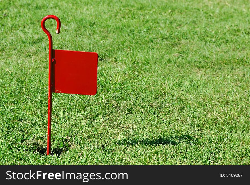 Red flag marker on novelty golf green