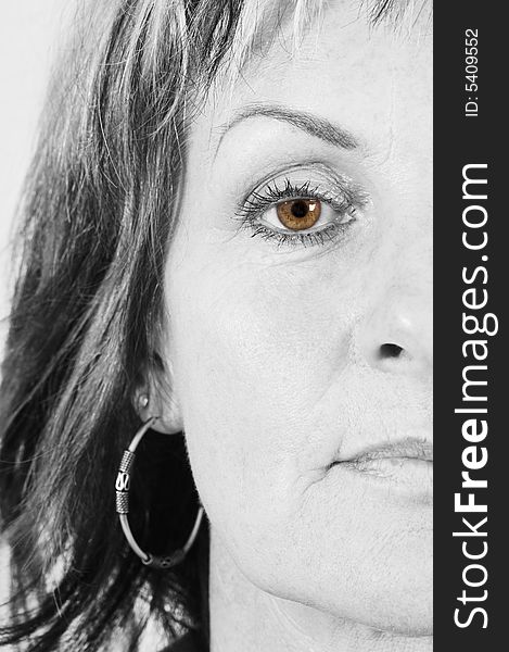 Close up of mature woman; half face B&W;eye iscolored. Close up of mature woman; half face B&W;eye iscolored