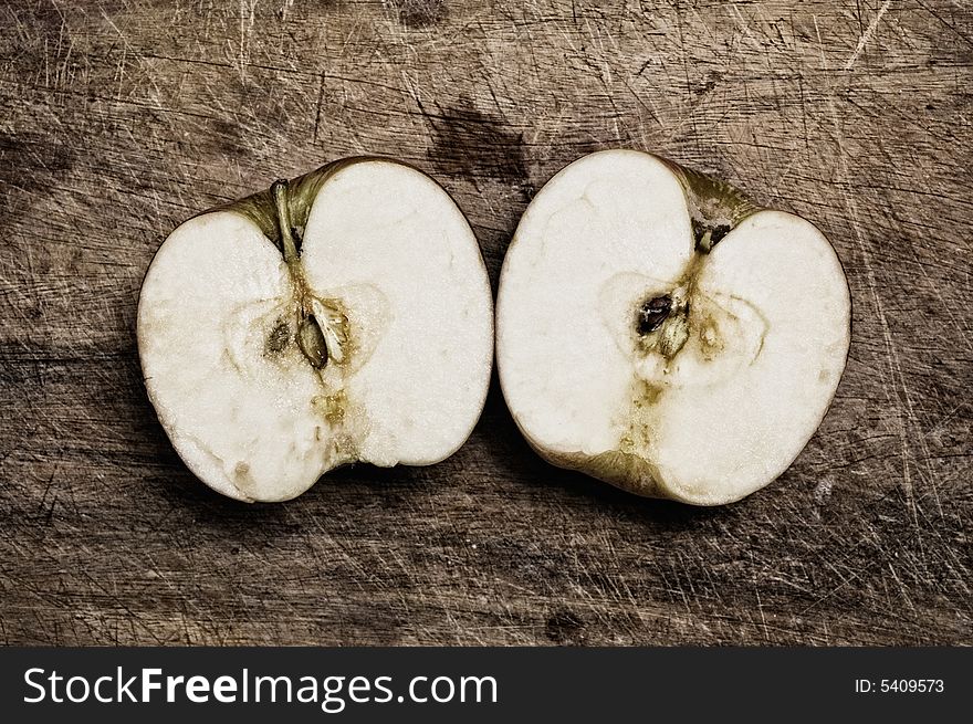 Cut apple on wooden table, studio closeup shot. Cut apple on wooden table, studio closeup shot.