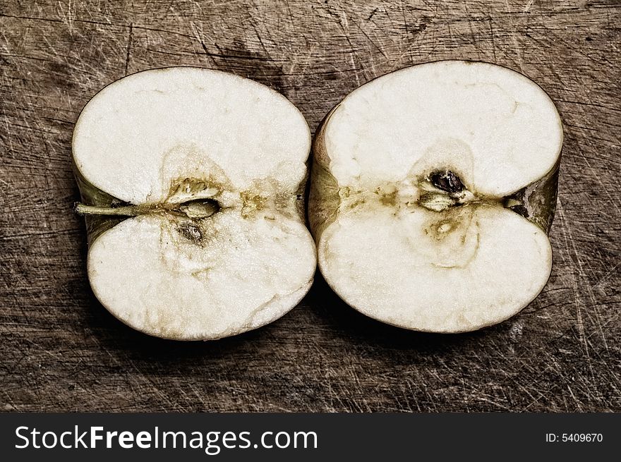 Cut apple on wooden table, studio closeup shot. Cut apple on wooden table, studio closeup shot.