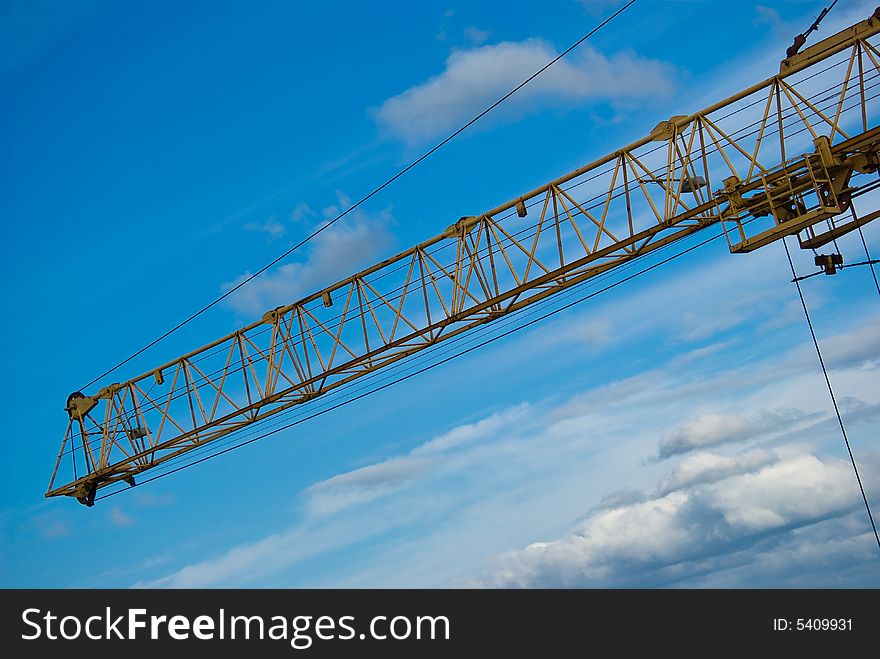 The elevating Crane, blue Sky and Clouds