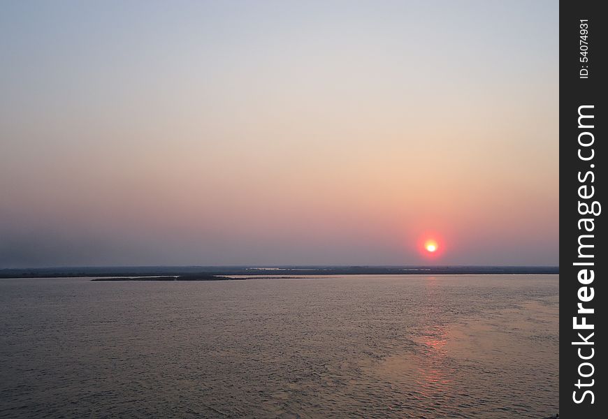 Sunset enveloped the river by the end of the passing day. Sunset enveloped the river by the end of the passing day.