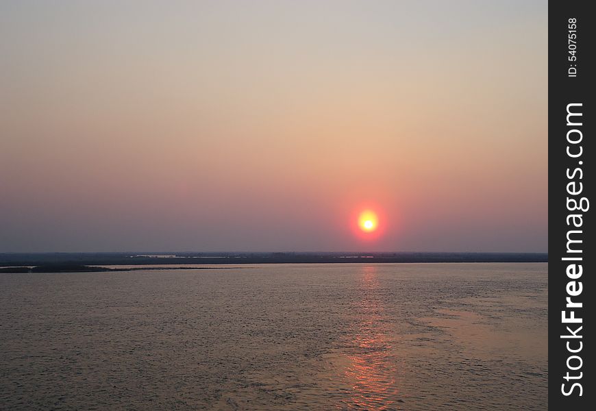 Sunset enveloped the river by the end of the passing day. Sunset enveloped the river by the end of the passing day.