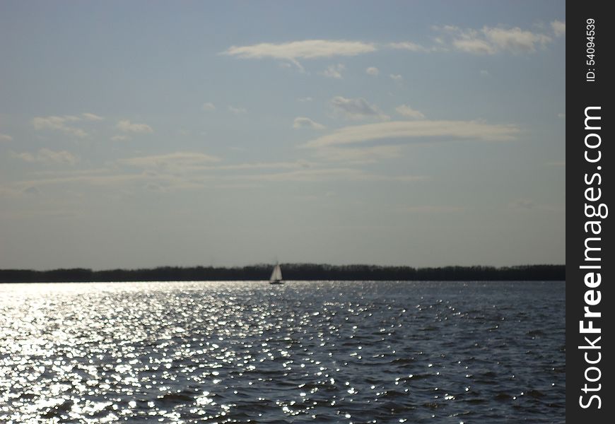 Sailboat floats alone on vast expanses of the river. Sailboat floats alone on vast expanses of the river.