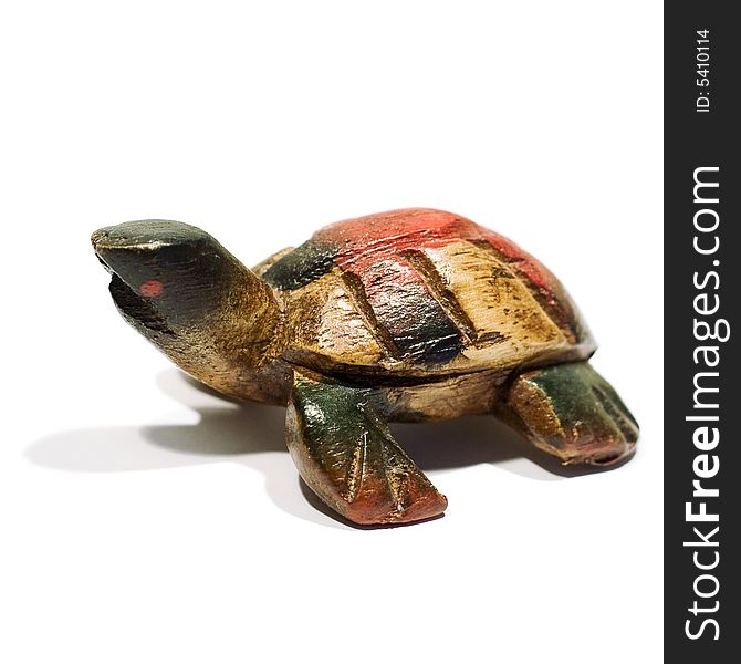 An isolated wooden toy shaped like a tortoise. An isolated wooden toy shaped like a tortoise.
