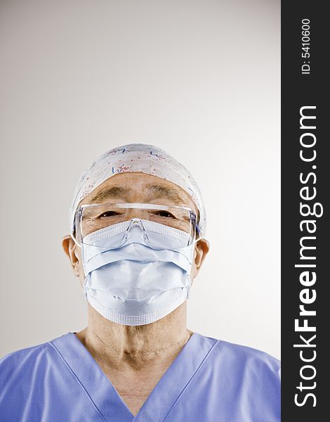 Senior asian doctor in surgical cap and mask