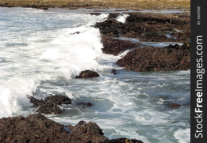 White water washing up onto rocks. White water washing up onto rocks