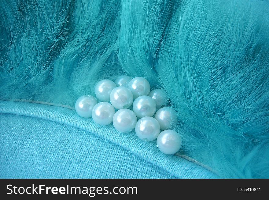 Pearl beads in fur on blue sweater. Pearl beads in fur on blue sweater