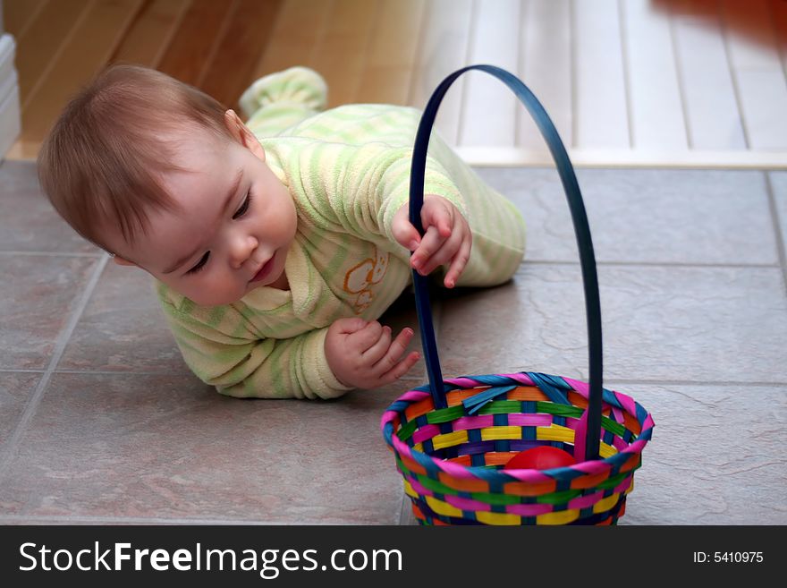 A baby boy in pajamas crawling to his Easter basket. A baby boy in pajamas crawling to his Easter basket