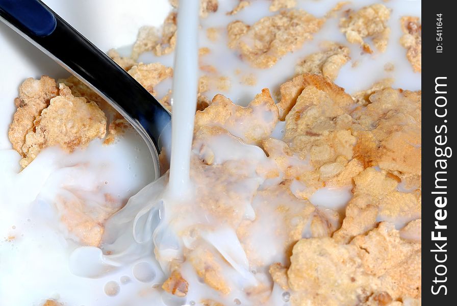 Milk pouring in a bowl of cereal corn flakes. Milk pouring in a bowl of cereal corn flakes
