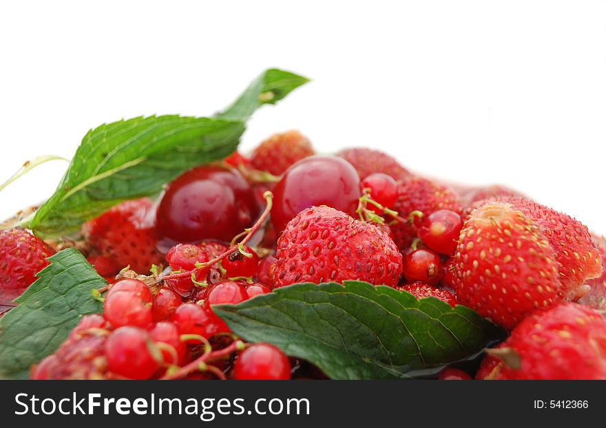 Bright red berries with green leaf on white background