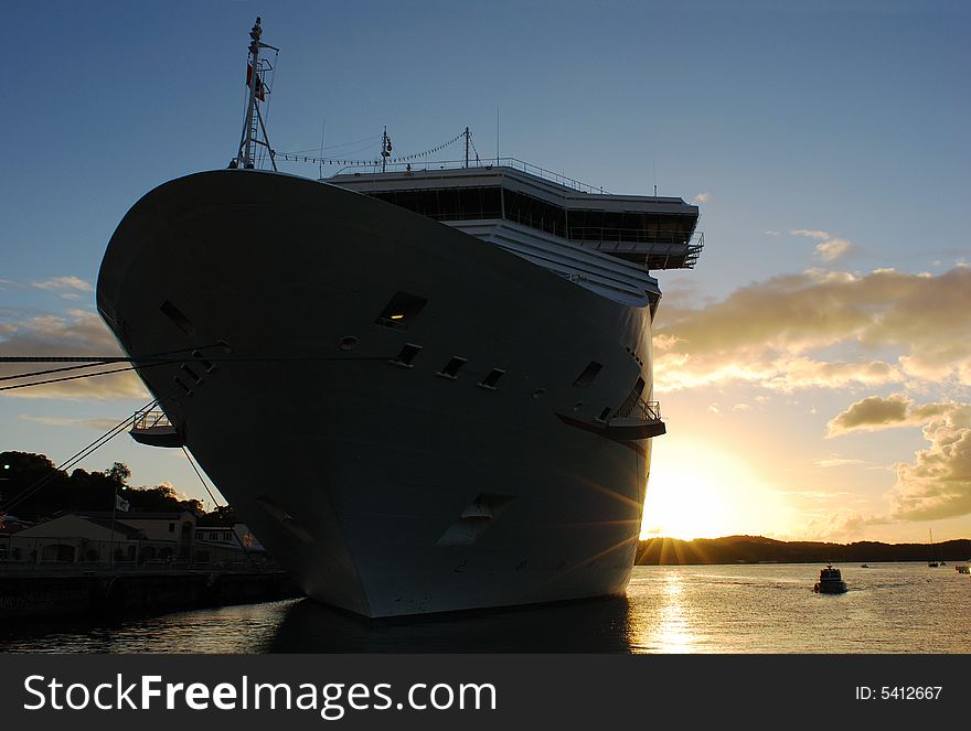 The cruise liner with the sun going down in a background on St.Thomas island, U.S. Virgin Islands. The cruise liner with the sun going down in a background on St.Thomas island, U.S. Virgin Islands.