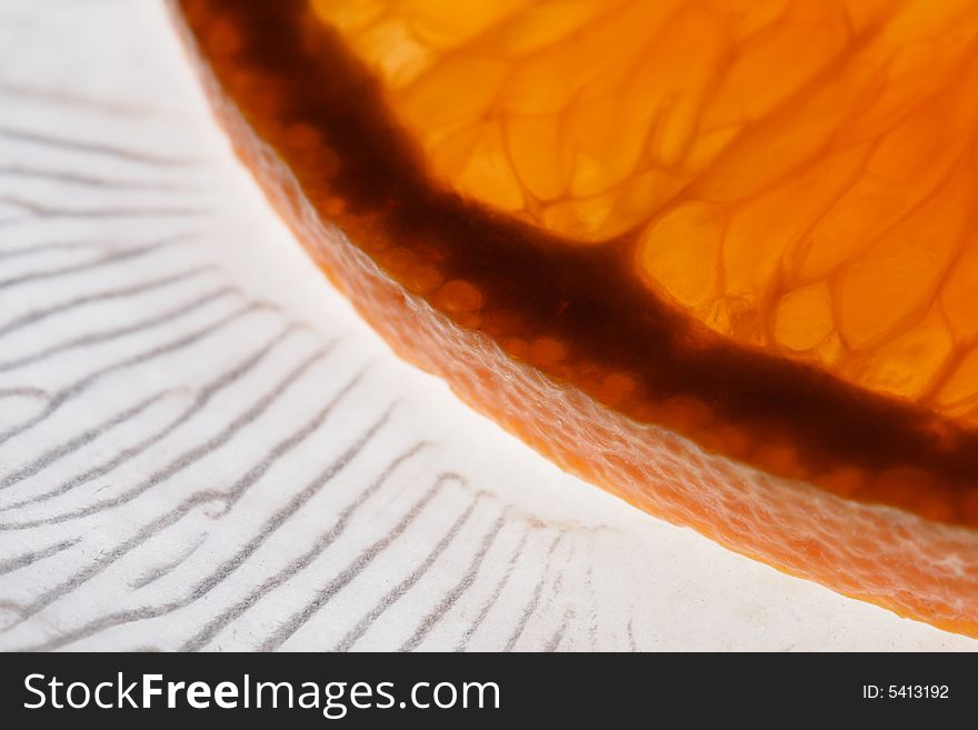 Orange on a glass plate with a pattern on it.