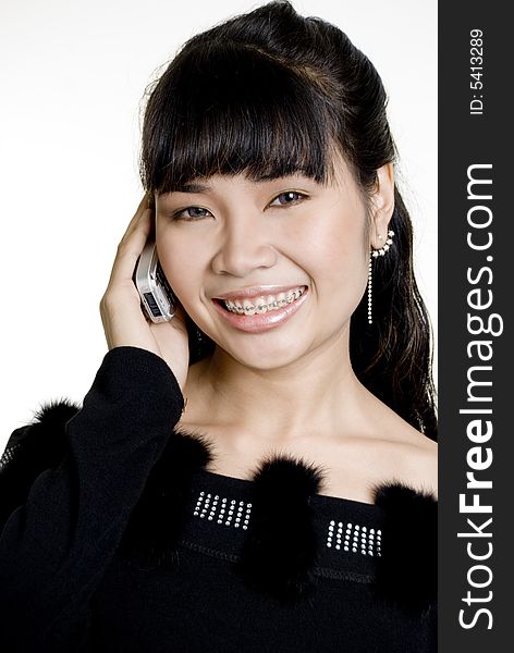 Smiling Asian woman using mobile phone, against white background. Smiling Asian woman using mobile phone, against white background