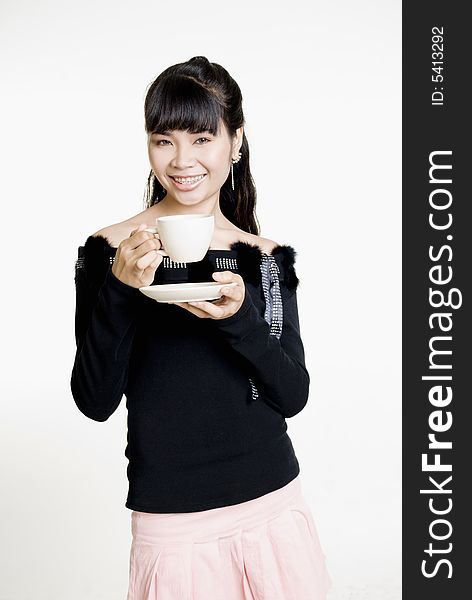 Asian woman with cup of coffee smiling at camera