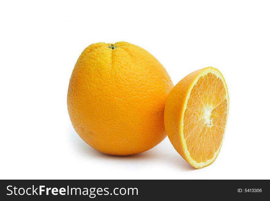 Oranges Isolated on white. One whole one and a piece of one balancing on the whole one.