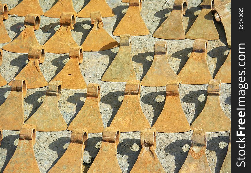 A bunch of rusty axe blades arranged in a line for sale. A bunch of rusty axe blades arranged in a line for sale