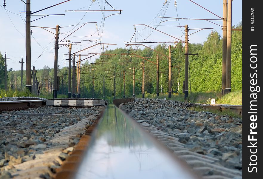 Straight railway track in summer sunrise