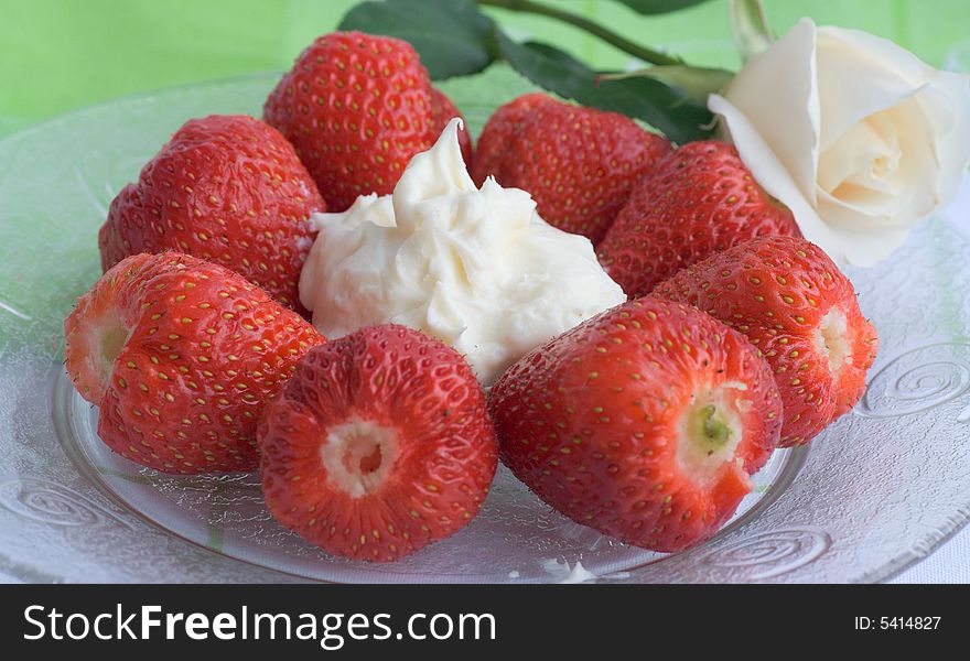Strawberry with leaves, with cream on a plate and Rose. Strawberry with leaves, with cream on a plate and Rose