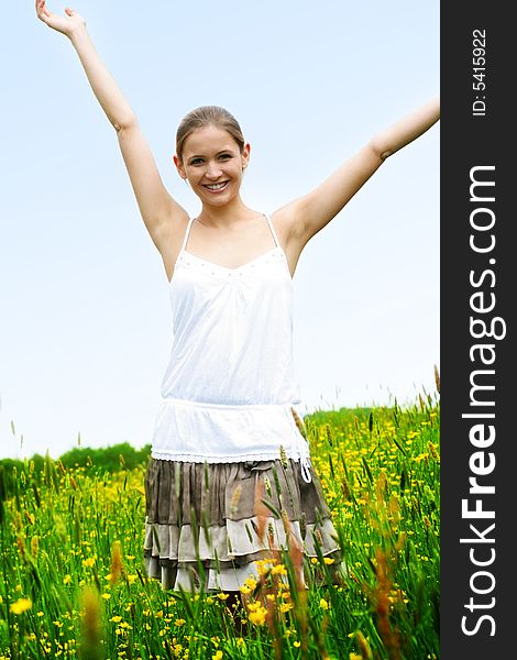 Happy woman on a meadow in front of the blue sky. Happy woman on a meadow in front of the blue sky